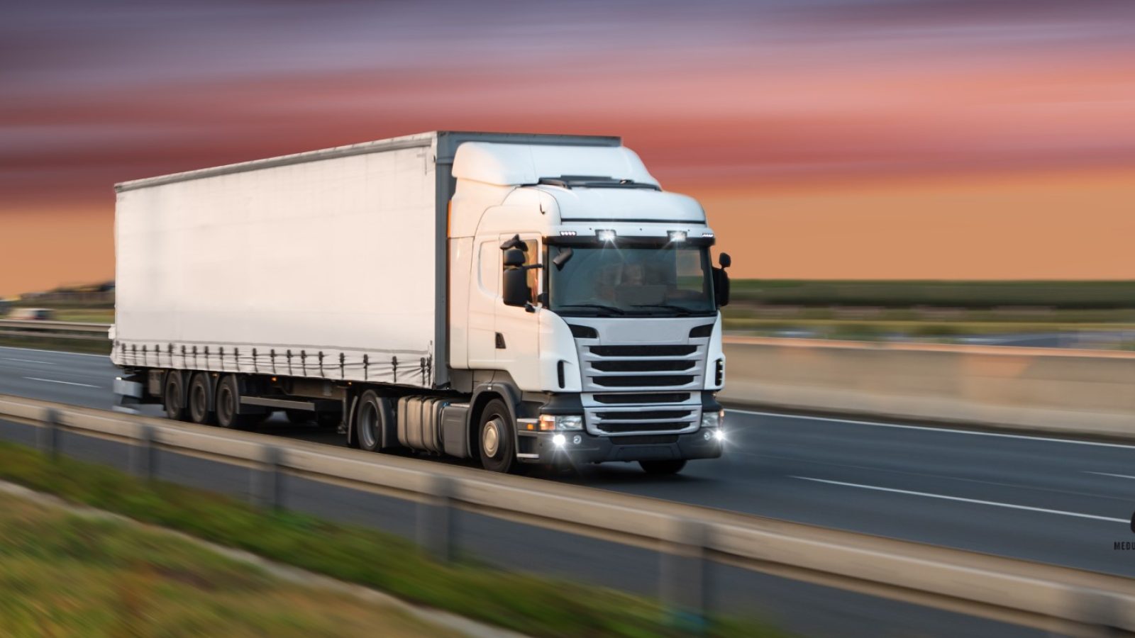 Kamion na autocesti pri zalasku sunca — međunarodni transport